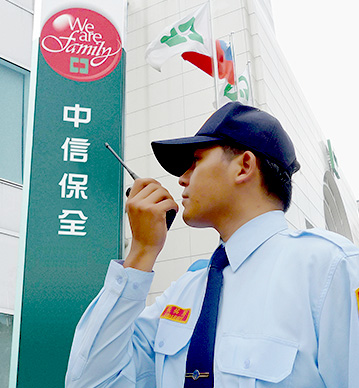 關於中信保全的介紹圖片,圖片中有一名保全拿著無線電站在中信保全招牌前