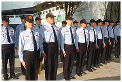 圖中有兩排保全站在廣場上
